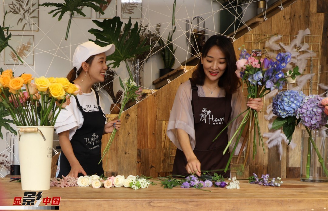 “昆明是鮮花的原產(chǎn)地，有亞洲最大的鮮切花交易市場(chǎng)，可以說具備開花店的天時(shí)地利；另外和很多女孩一樣，我從小也就有開花店的夢(mèng)想！”說起當(dāng)初的決定，王黎媛說一是因?yàn)閴?mèng)想，另外也跟昆明這個(gè)城市產(chǎn)花、賣花的“基因”有關(guān)。圖為王黎媛和同事在制作花束。新華網(wǎng) 周亞平/攝 念新洪/文